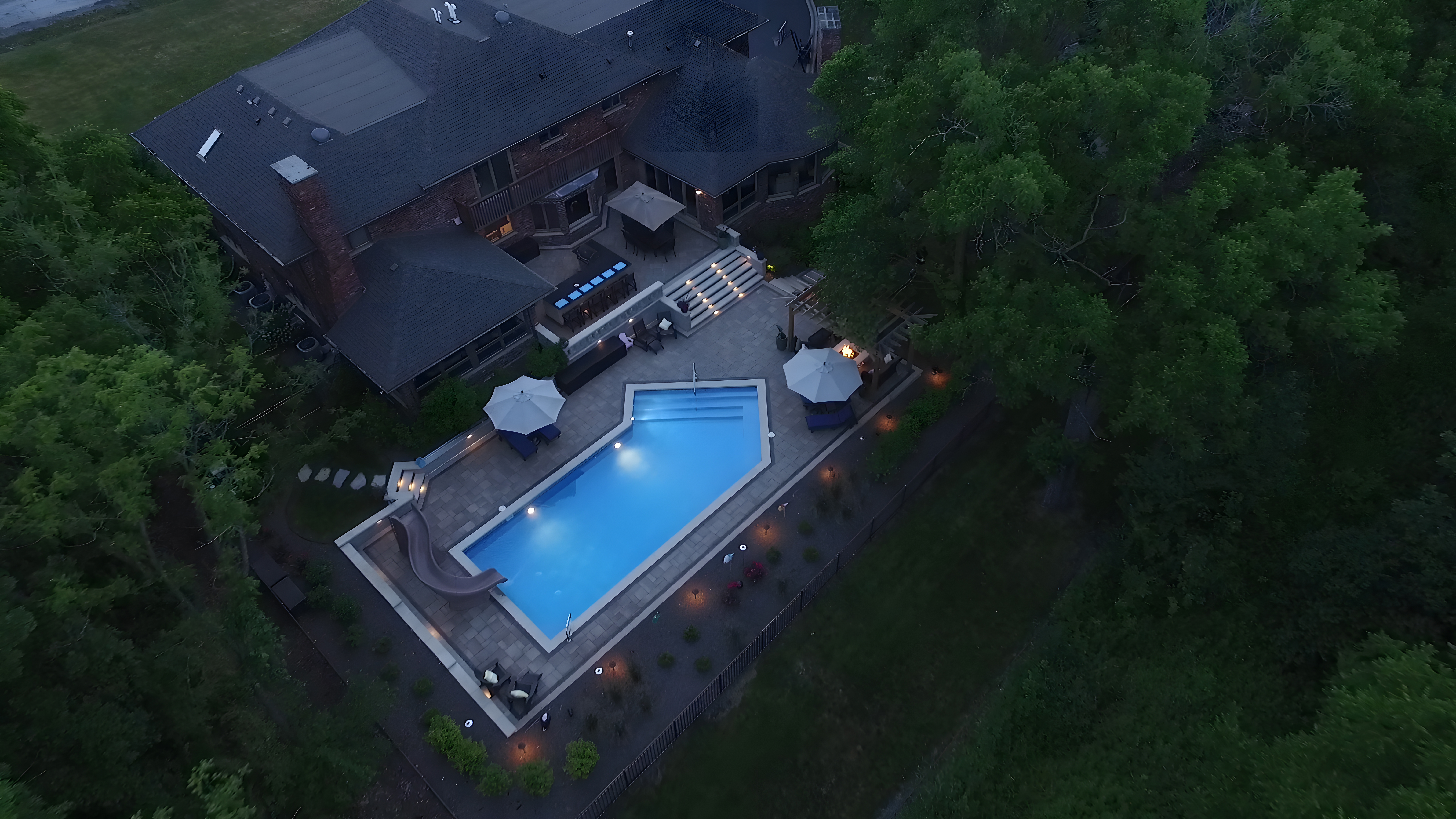 Aerial dusk view of luxury residence with pool